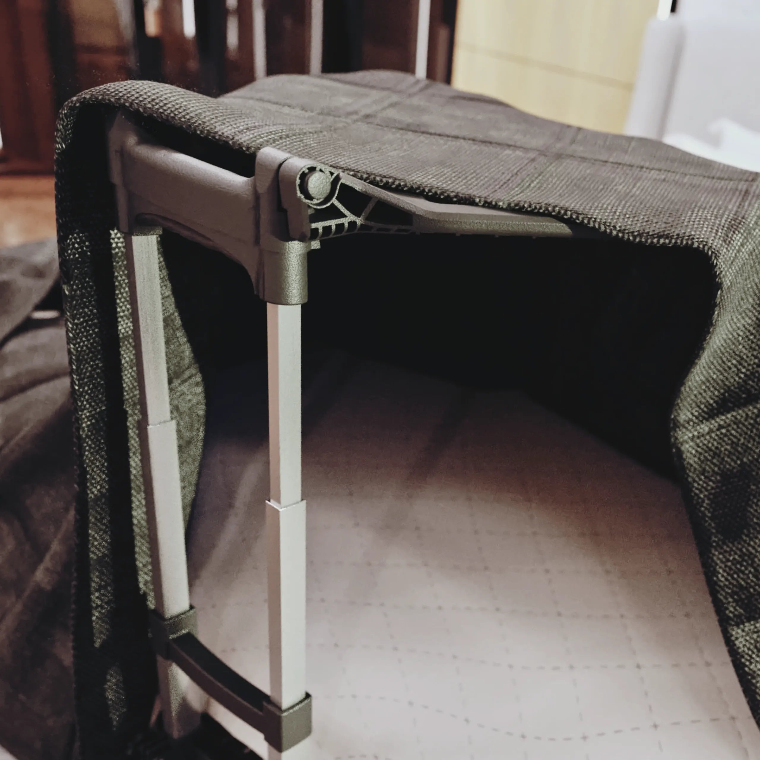 An image of an easy lift Asigh blanket lifter / blanket lift that is holding up a green blanket